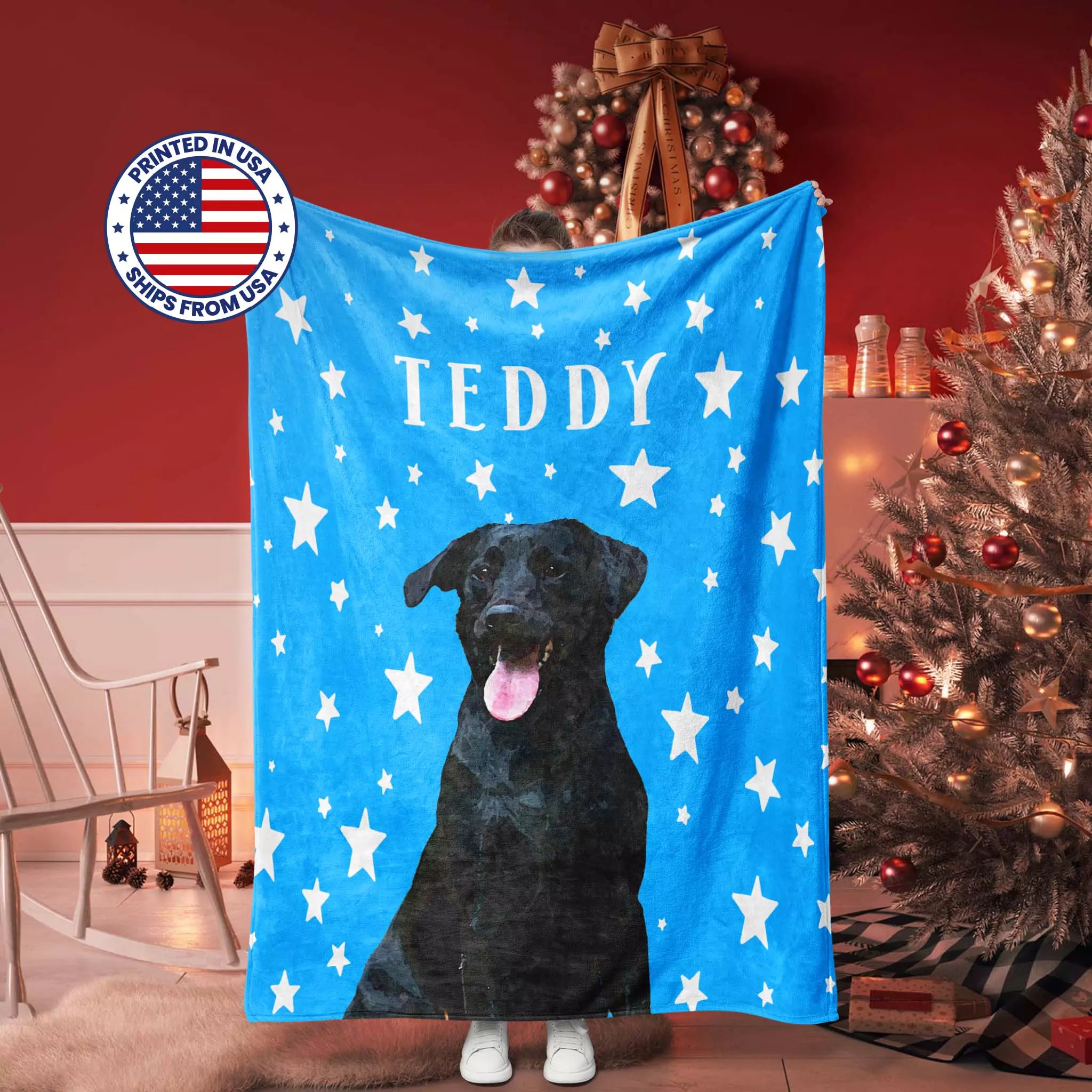 Blue dog blanket with a black dog illustration and 'TEDDY' text, displayed in a room with Christmas decorations.