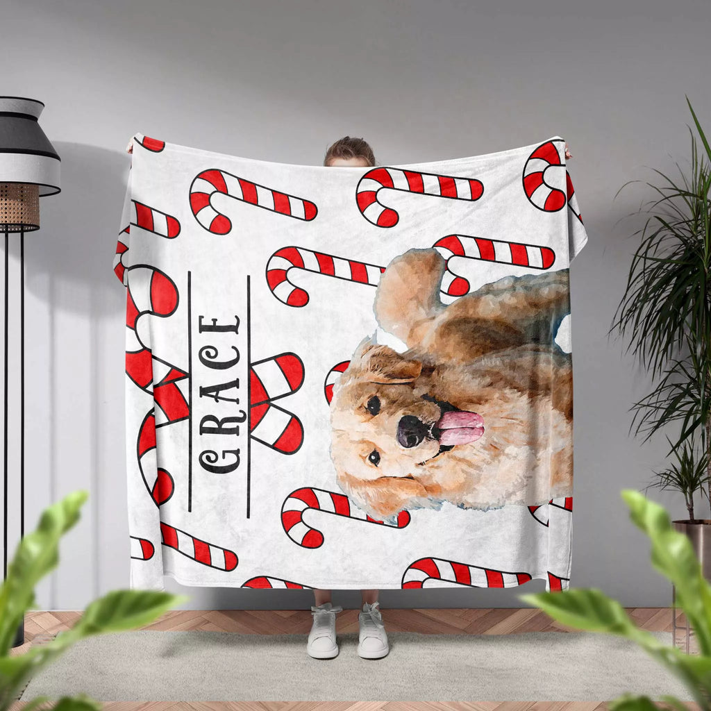 Person holding a blanket with a Golden Retriever dog and candy canes design, with 'Grace' printed on it.