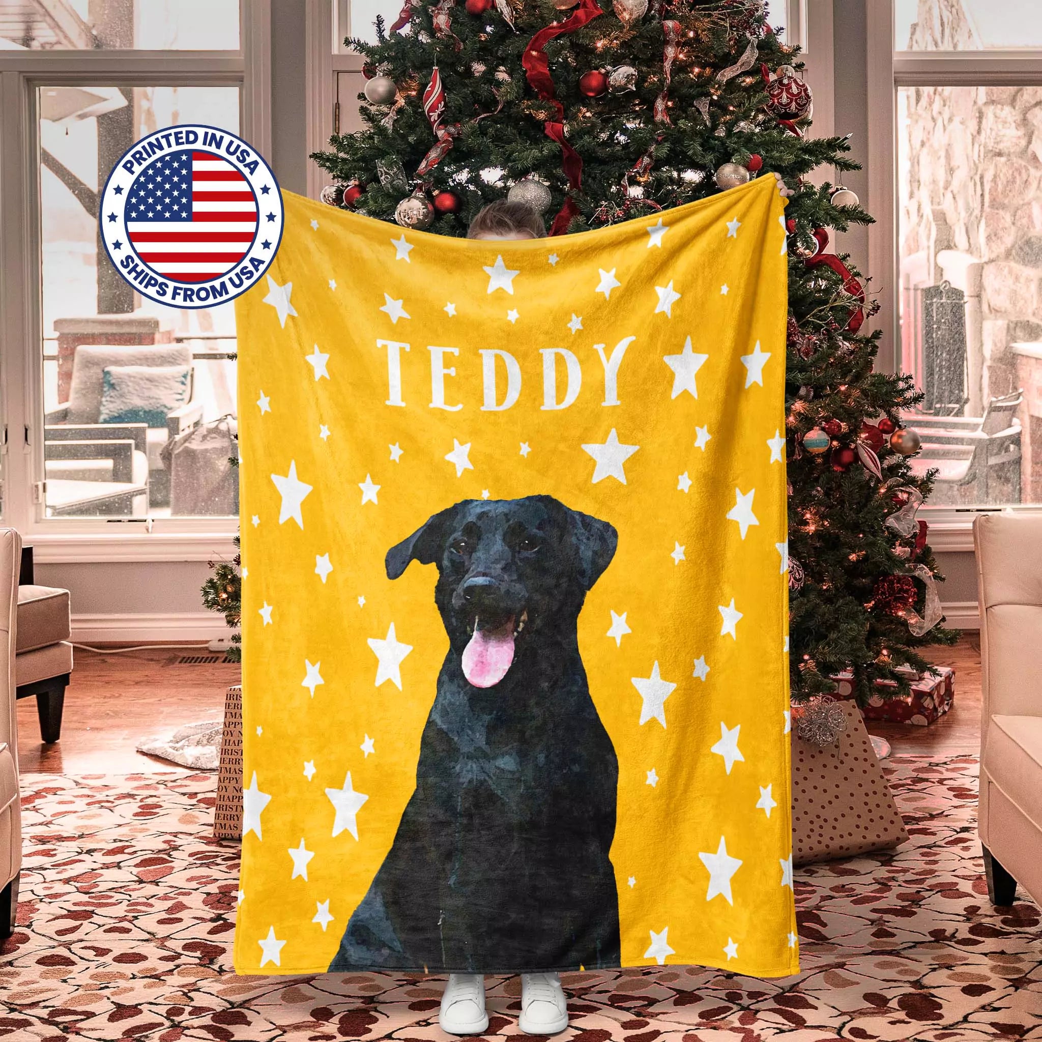 Yellow Christmas dog blanket with a black Labrador dog illustration and 'TEDDY' text, displayed in a room with a Christmas tree.