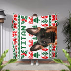 Person holding a dog blanket with a dog's face and Christmas patterns