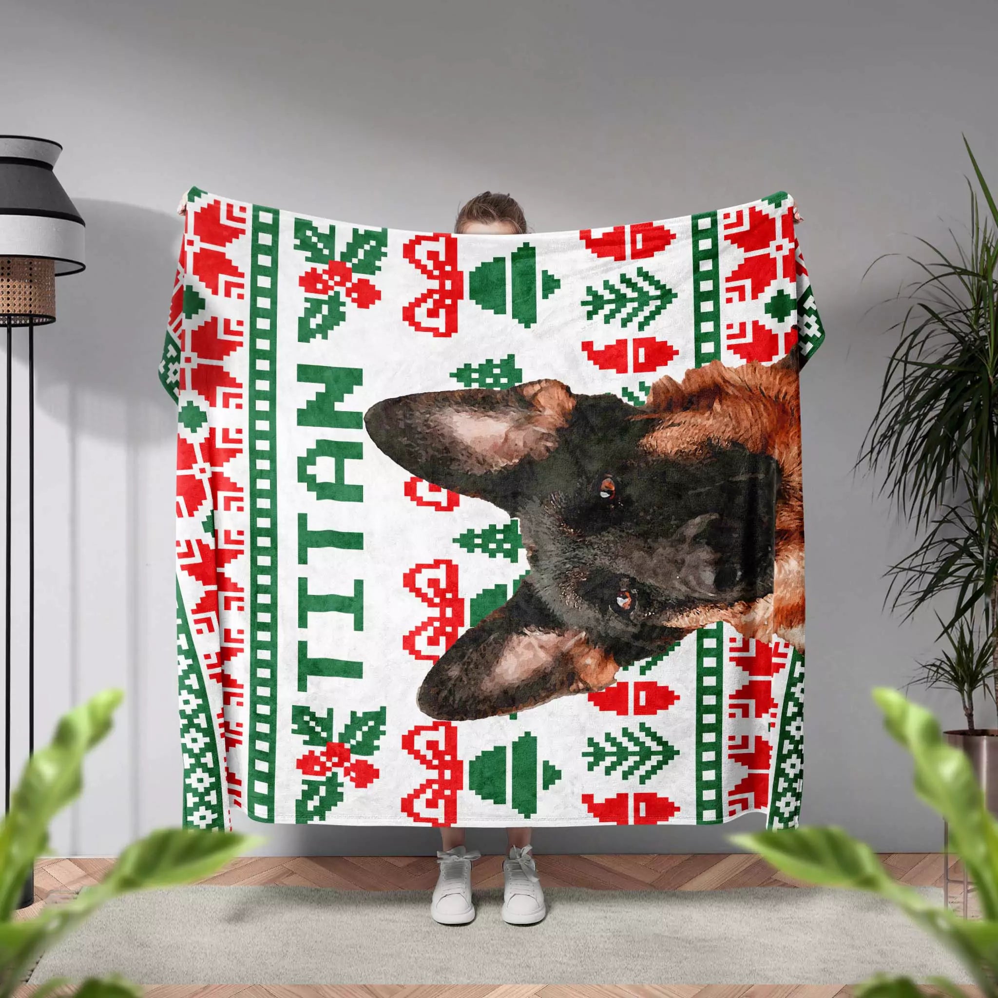 Person holding a dog blanket with a dog's face and Christmas patterns