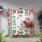 Person holding a Christmas ugly sweater dog blanket with a dog's face and Christmas patterns