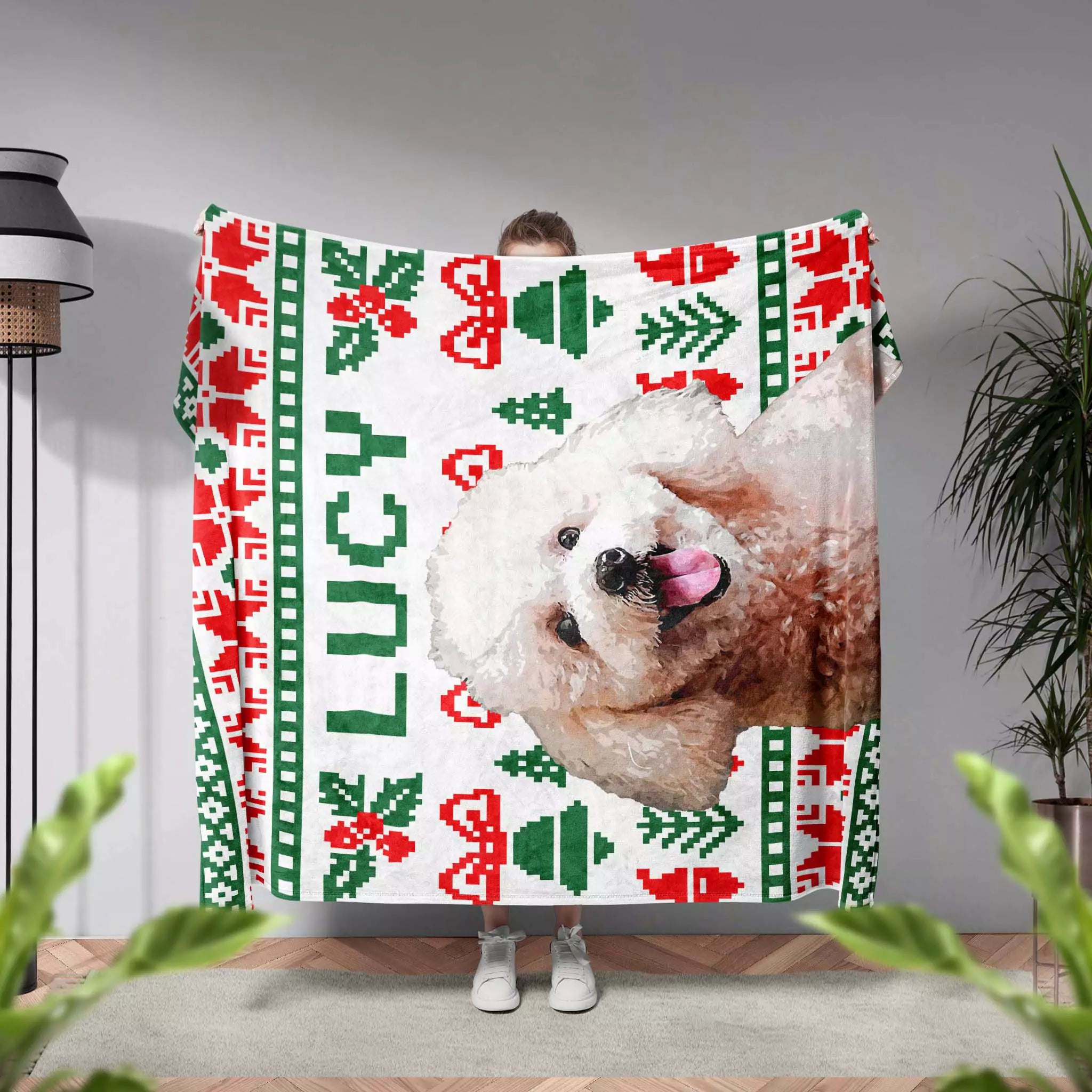 Person holding a Christmas ugly sweater dog blanket with a dog's face and Christmas patterns