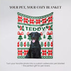 Dog standing behind a Christmas-themed blanket with 'TEDDY' printed on it.