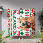 Person holding a Christmas ugly sweater custom dog blanket with a dog's face and Christmas patterns, with 'GRACE' printed on it.