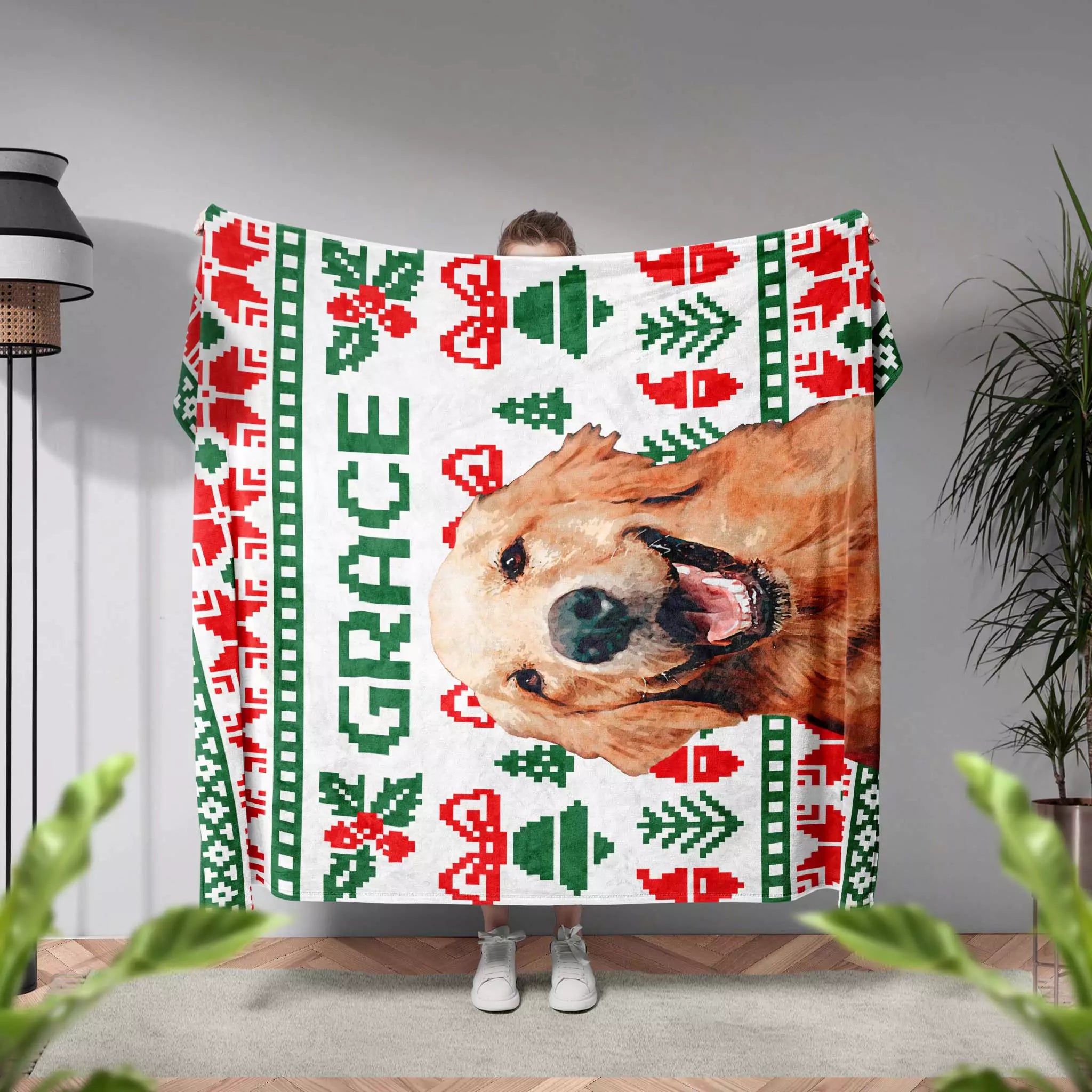 Person holding a Christmas ugly sweater custom dog blanket with a dog's face and Christmas patterns, with 'GRACE' printed on it.
