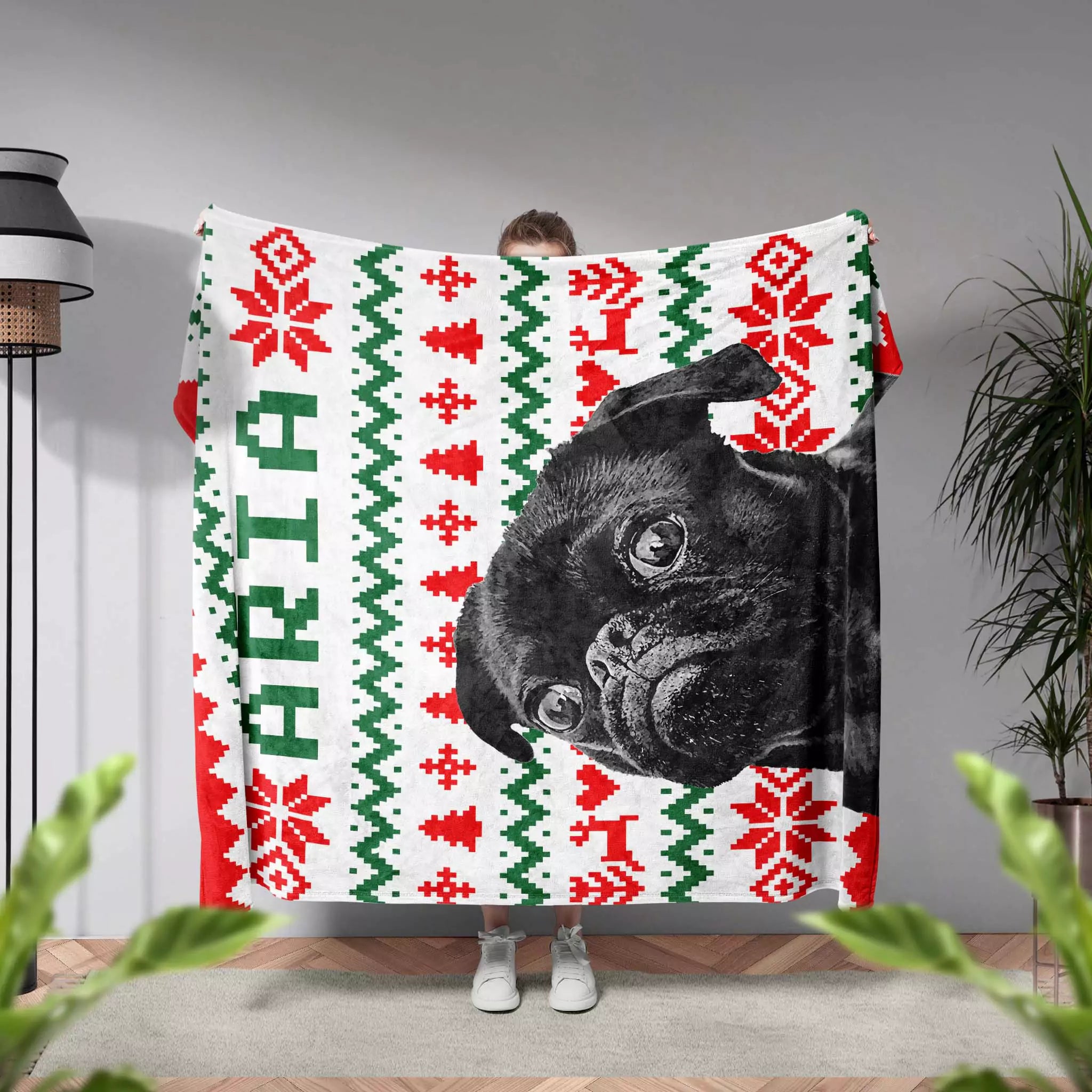 Person holding a festive dog blanket with a black dog's face and 'Aria' monogrammed name text.