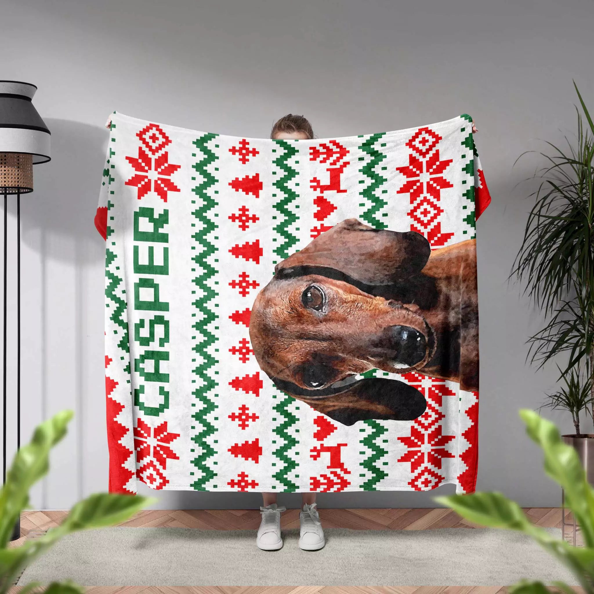 Person holding a Christmas-themed ugly sweater blanket with a Dachshund dog's face and 'Casper' text.