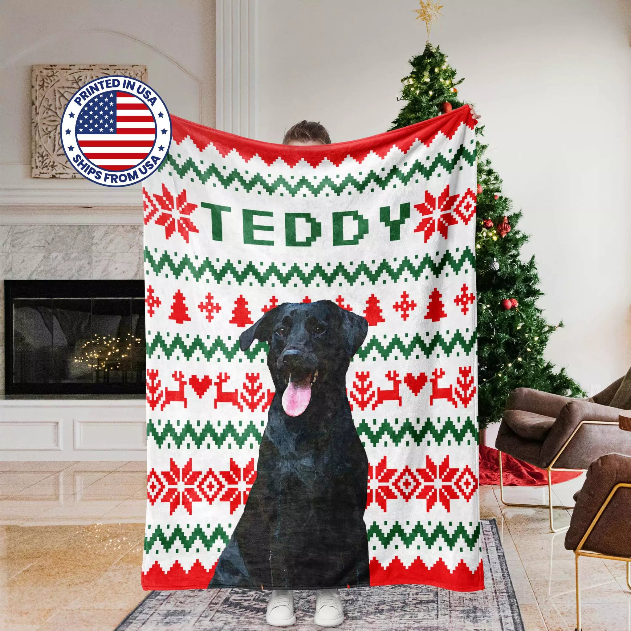 Person holding a Christmas ugly sweater blanket with a dog's face on it, in a living room setting.