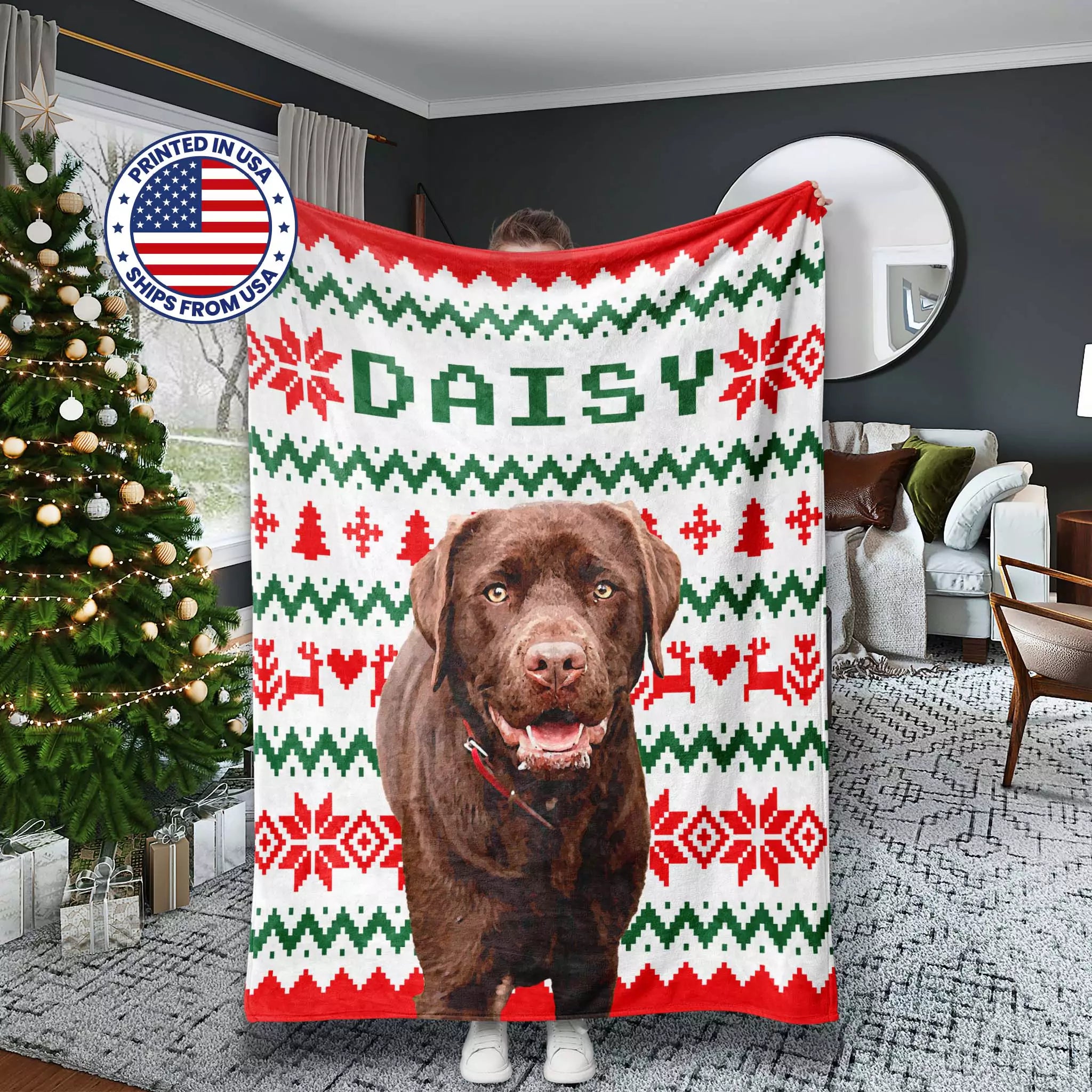 Christmas-themed dog blanket with a dog's face printed on it, held by a person in a living room.