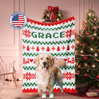 Golden Retriever Dog standing in front of a Christmas-themed blanket with 'GRACE' printed on it, surrounded by festive decorations.